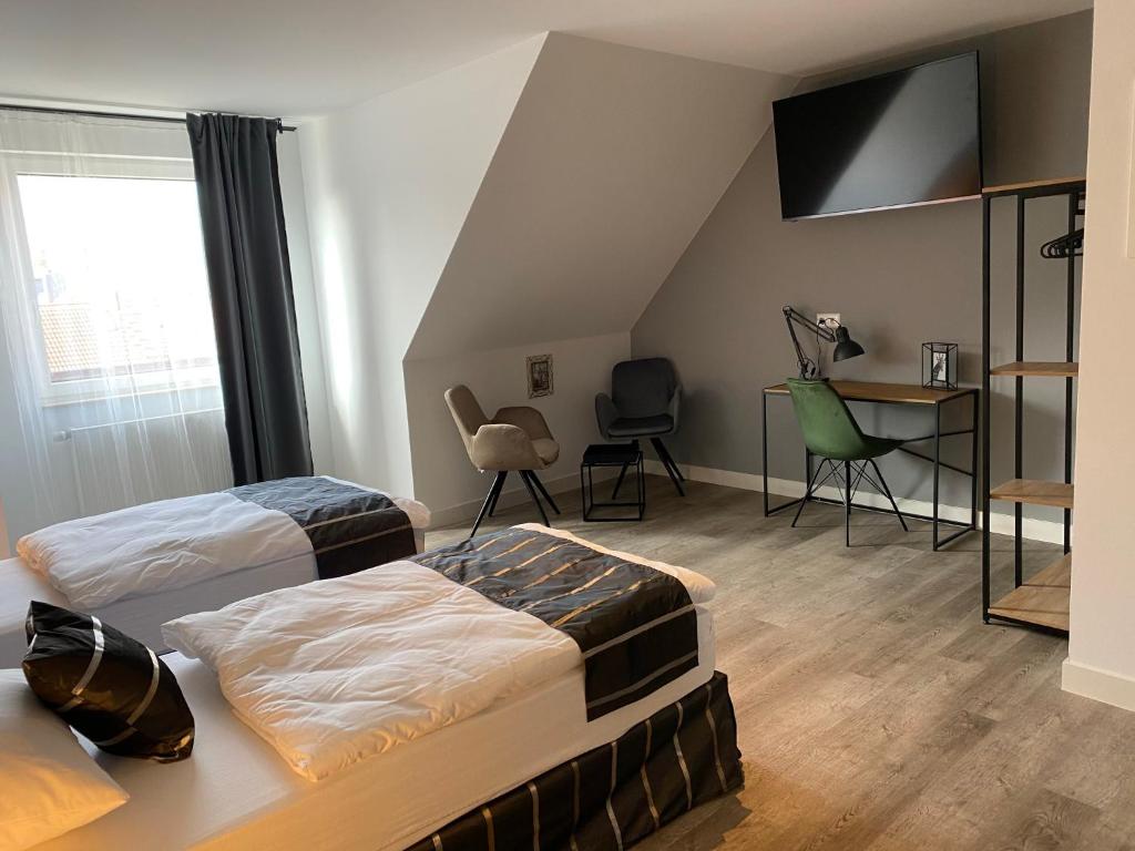 汉诺威Aparthotel Charlotten的一间卧室配有两张床和一张桌子及椅子