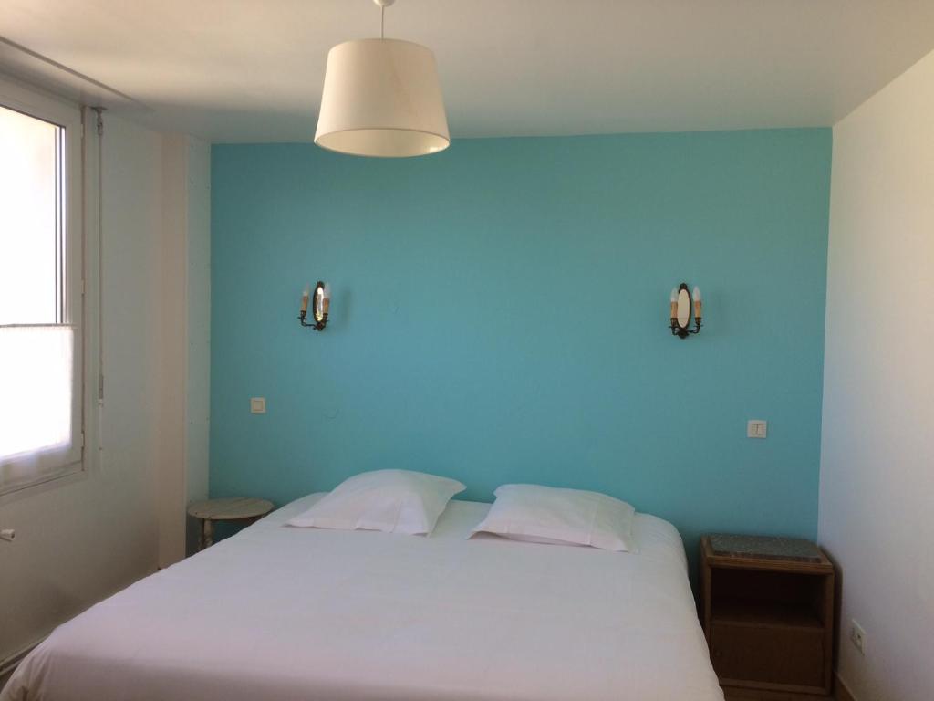 加来独特黎希留酒店的卧室配有白色床和蓝色墙壁