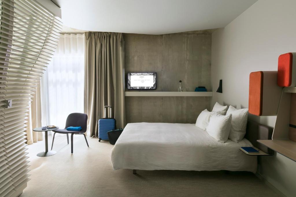 斯特拉斯堡斯特拉斯堡中心奥克酒店的配有一张床和一把椅子的酒店客房