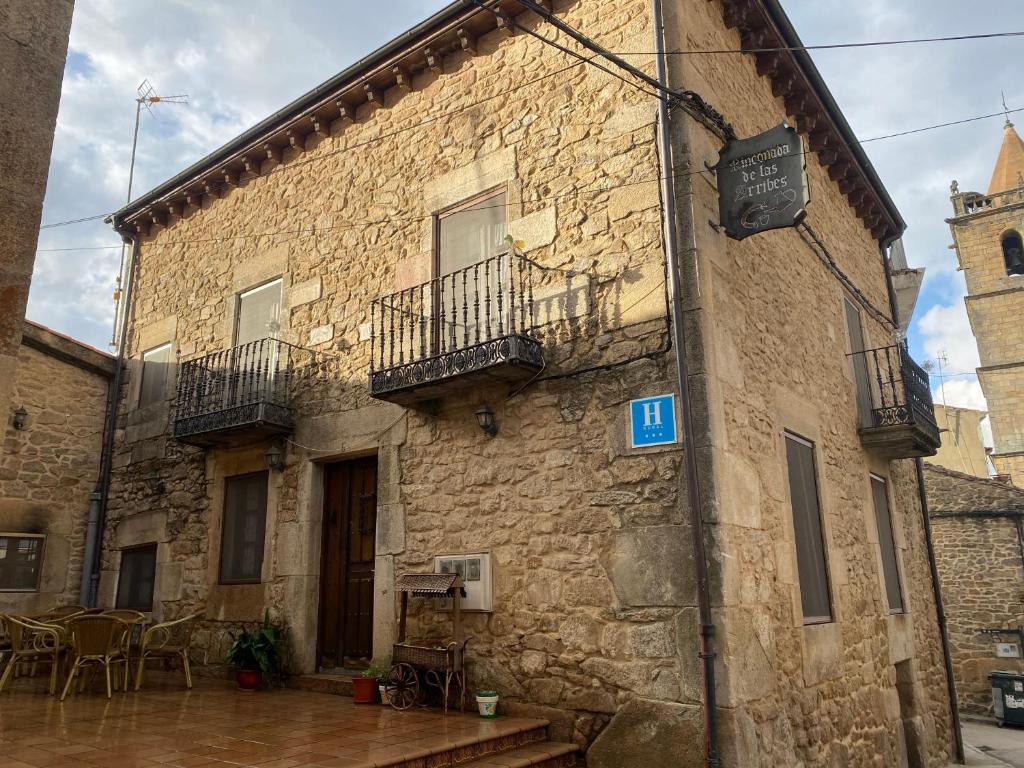 阿尔德亚达维拉德拉里韦拉Hotel rural Rinconada de las Arribes的石头建筑,设有两个阳台和桌子