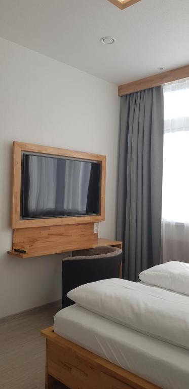 梅青根HB 32 Metzingen的酒店客房设有两张床和一台平面电视。