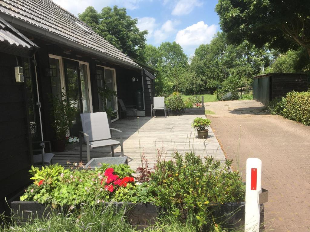兹沃勒Klein Vreugderijk的房屋前方带椅子和鲜花的庭院