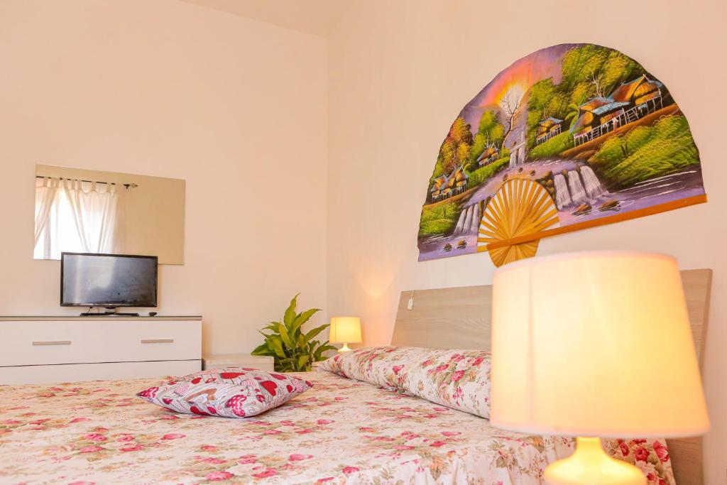 伊斯基亚Mini Hotel Rendez Vous的一间卧室配有一张带灯具的床和一台电视
