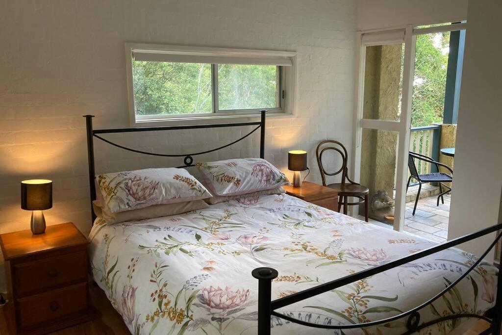 尼尔森湾Kookaburra Retreat的一间卧室配有一张床、两盏灯和一个窗户。