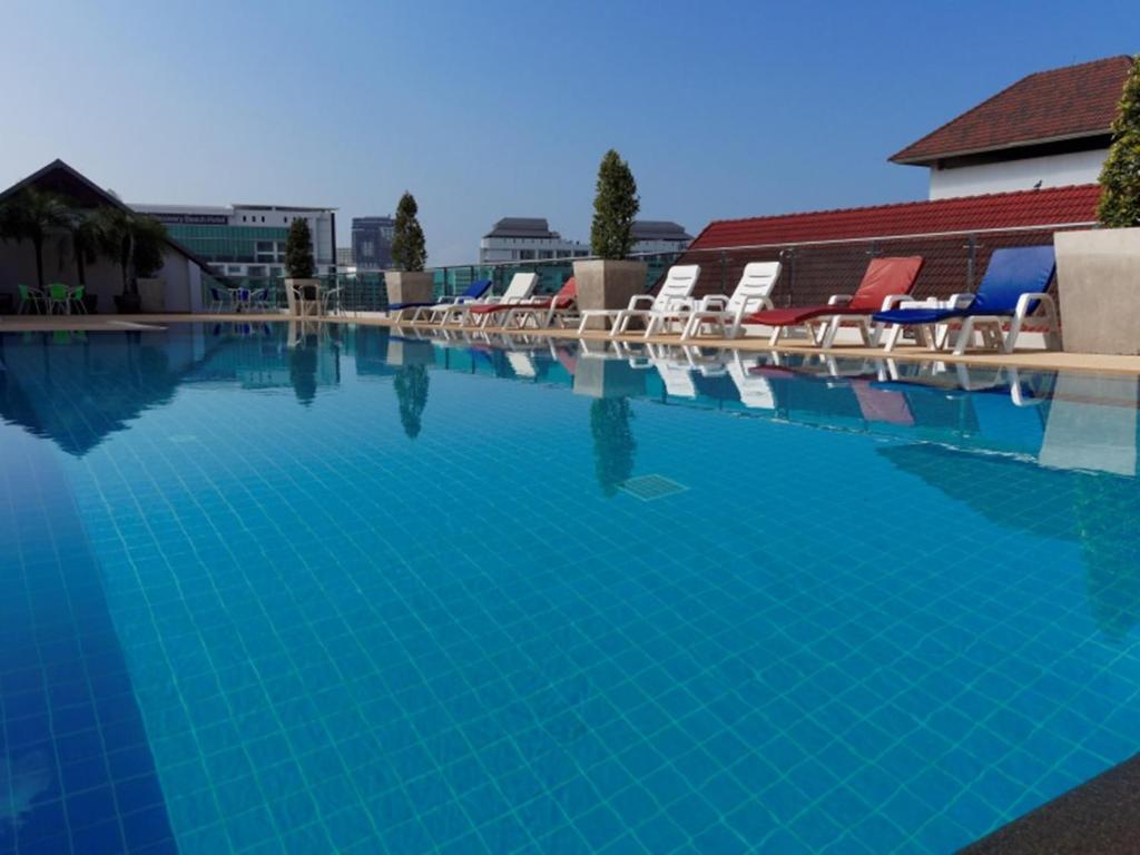 芭堤雅市中心芭堤雅蓝天酒店的一个带椅子和蓝色水的大型游泳池