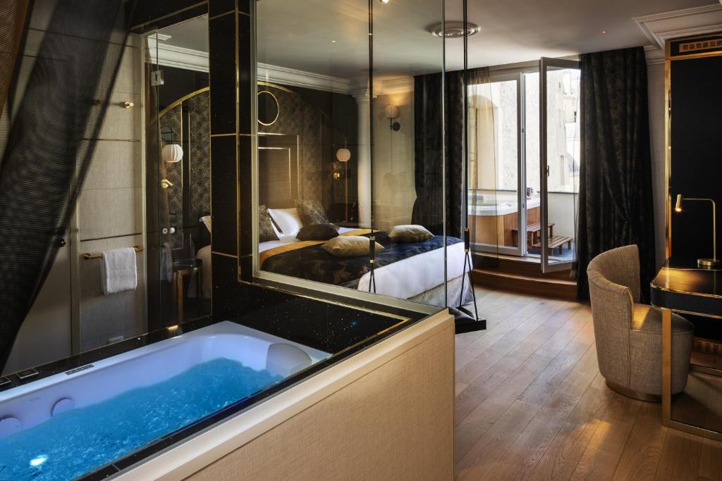 巴黎Paris j'Adore Hotel & Spa的酒店客房设有浴缸和卧室。