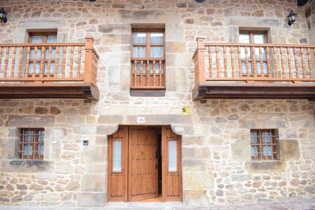 CartesVuelta Abajo Un lujo a tu alcance en Cartes的石头建筑,设有木制阳台和门