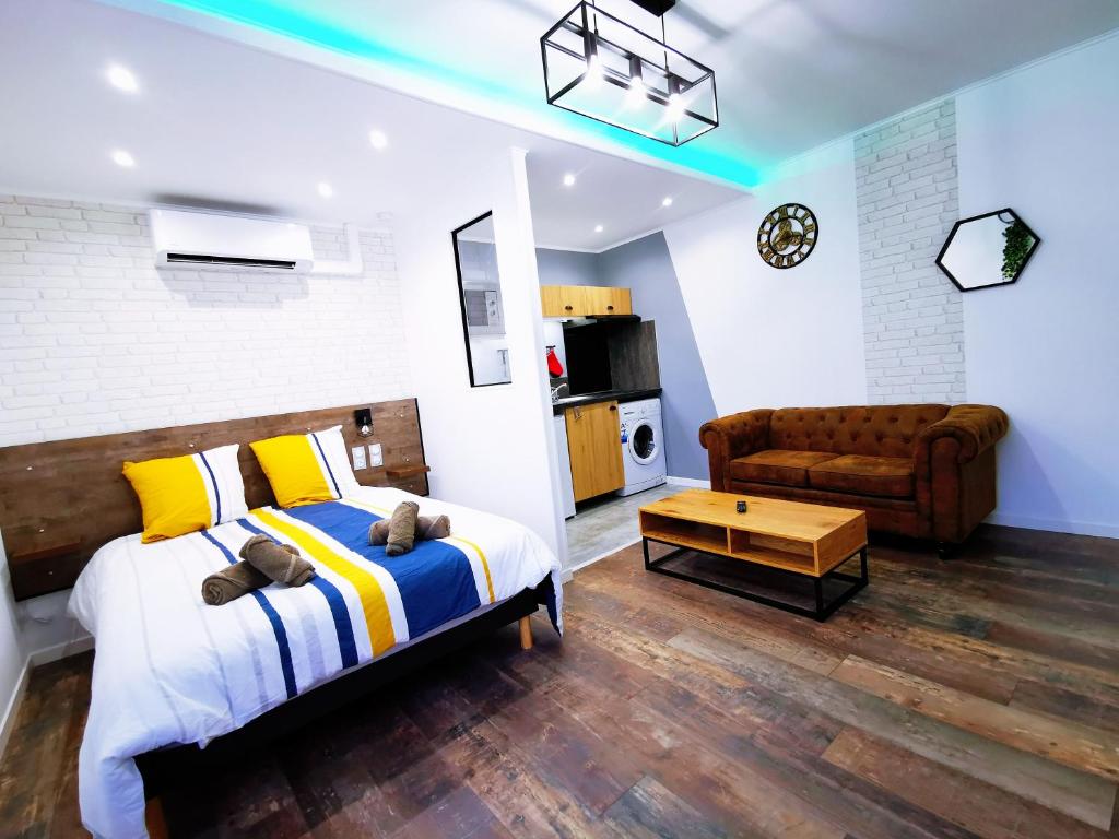 里摩日Skyline Residence "Smart-Concept"的一间卧室配有一张床,客厅配有沙发