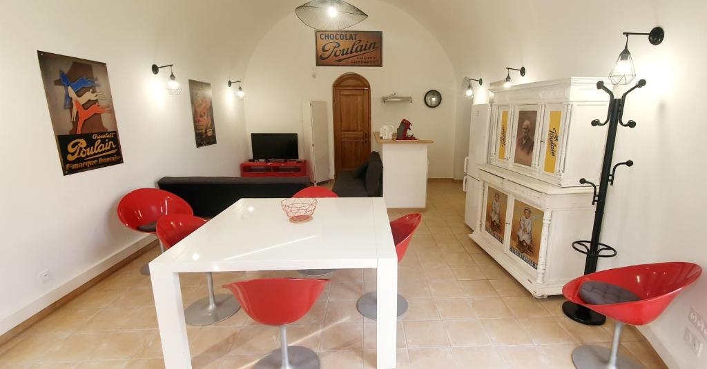 布鲁瓦Appartement "La Chocolaterie" en Centre-Ville linge inclus的客厅配有白色桌子和红色椅子