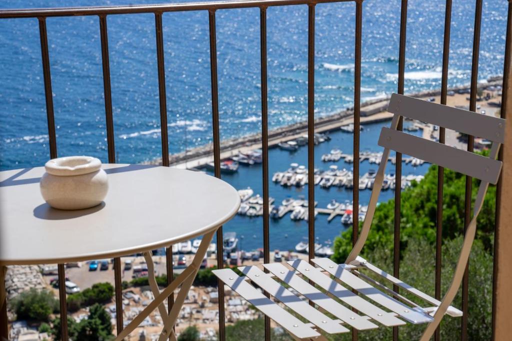 卡尔热斯Cargèse, appartement de charme surplombant le port的一个带海港的阳台的桌子和椅子
