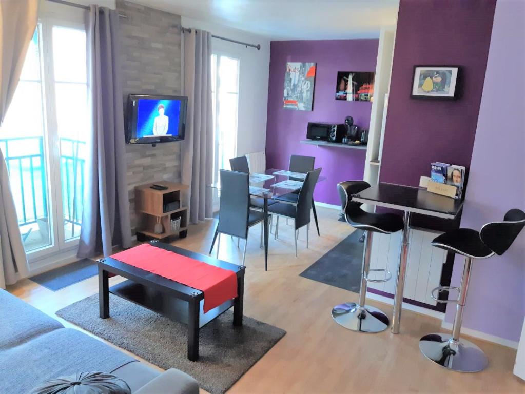 谢西Briget Apartment的客厅设有紫色墙壁和桌椅