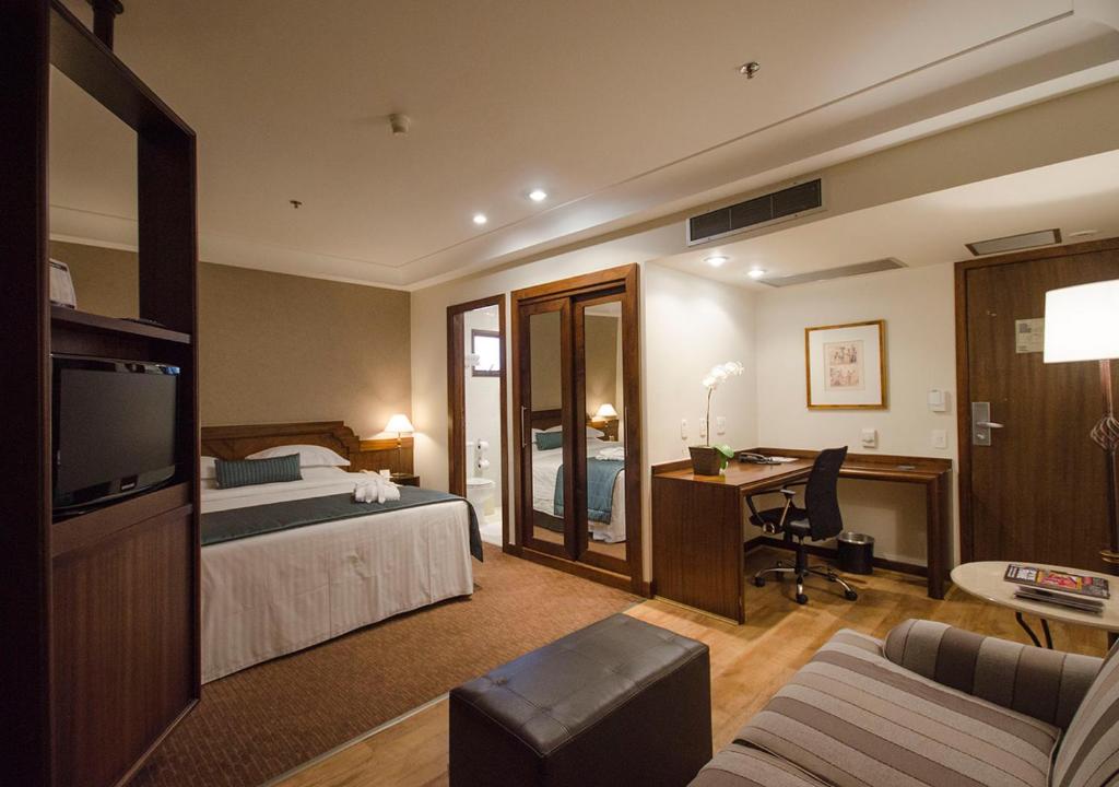 圣保罗伊斯坦广场普利司塔酒店的配有一张床和一张书桌的酒店客房
