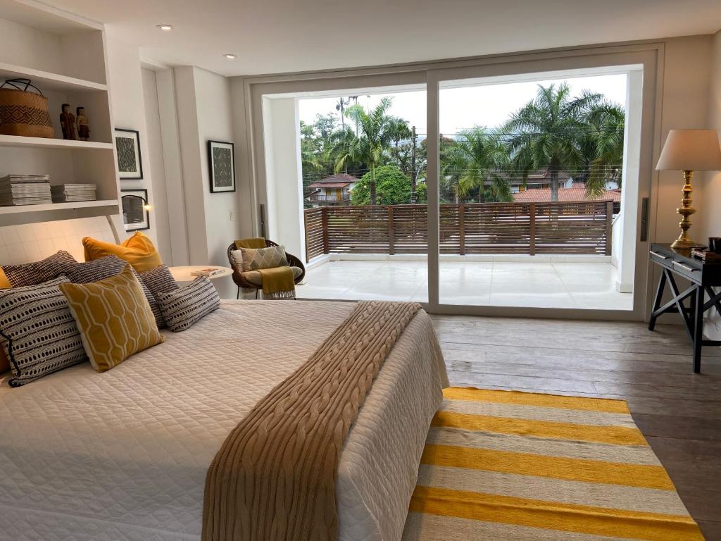 帕拉蒂Tropical Contemporary Suites的一间卧室设有一张大床和一个大窗户