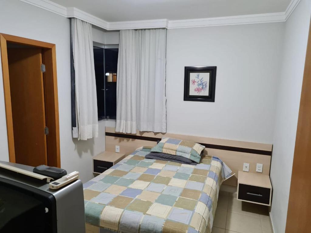 热河市Rio Quente Aguas da Serra Apart的一间卧室配有一张床和一台电视。