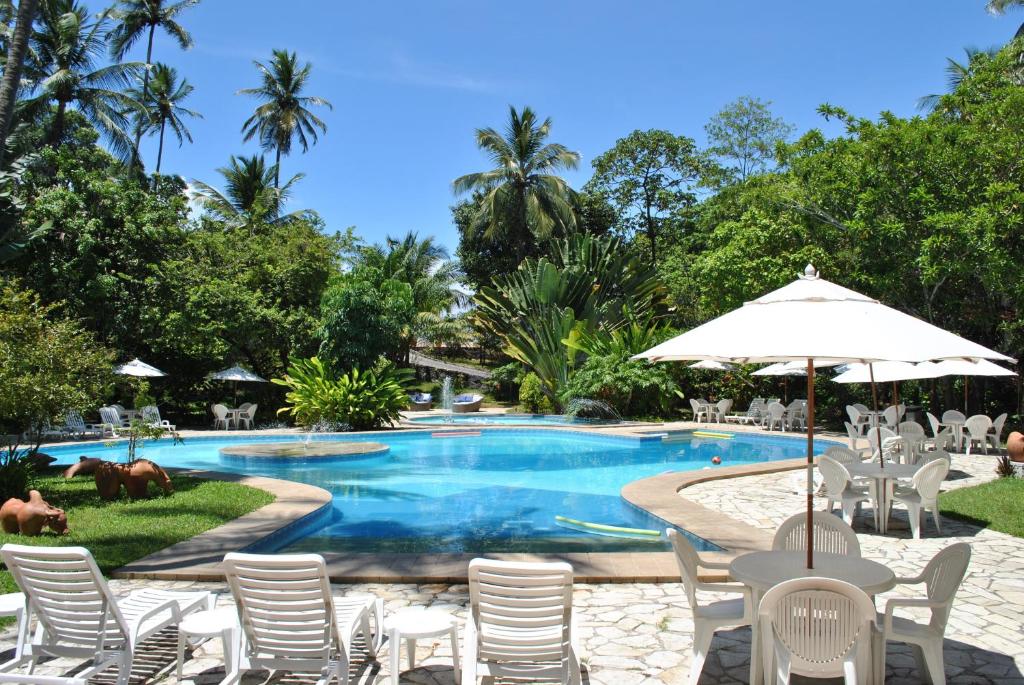 奥林达拉斯科琳娜7号酒店的一个带椅子和遮阳伞的度假村游泳池