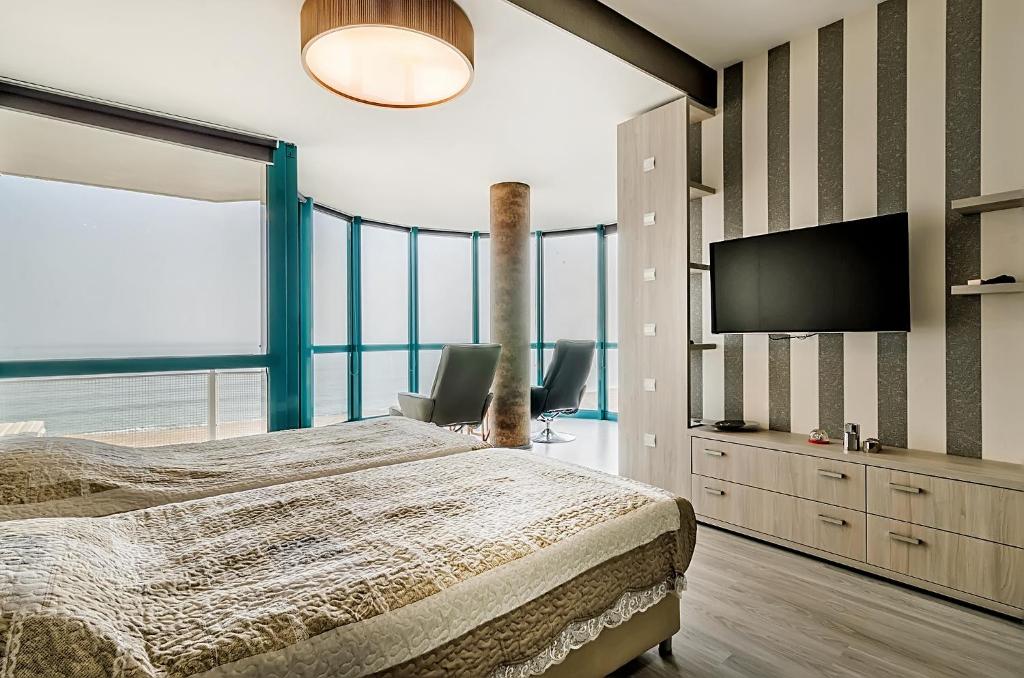 金沙Alek Apart Golden Sands的一间卧室配有一张床和一台平面电视
