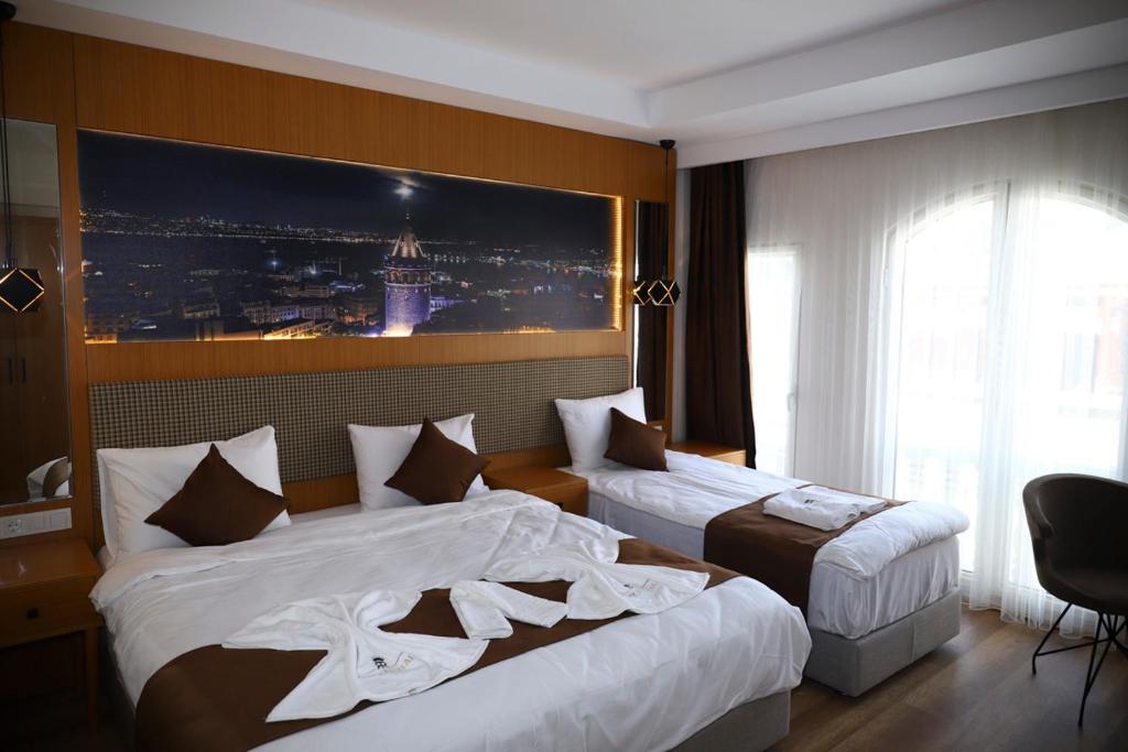 伊斯坦布尔Ruby Royal的酒店客房设有两张床,墙上挂着一张照片。