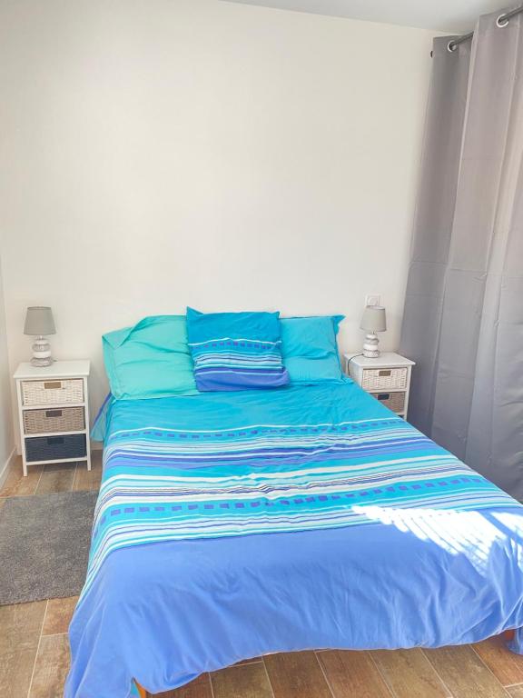 奥雷龙圣皮耶尔Le sable chaud的卧室内的蓝色床和蓝色枕头