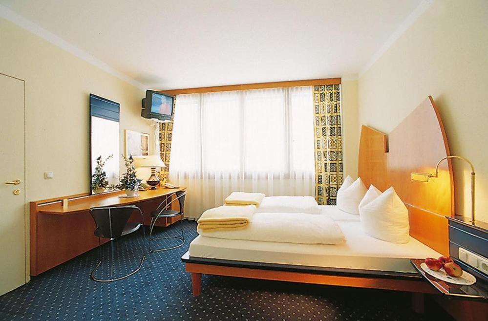 圣卡尼兹Appartement Hotel Marolt的一间卧室配有一张床、一张桌子和一个水槽