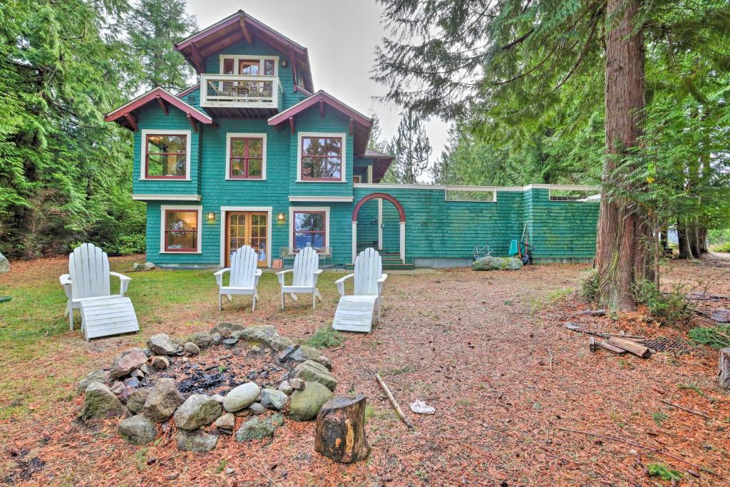 LopezLopez Island Hideaway with Coastal Views and Deck!的蓝色的房子,配有白色的椅子和火坑