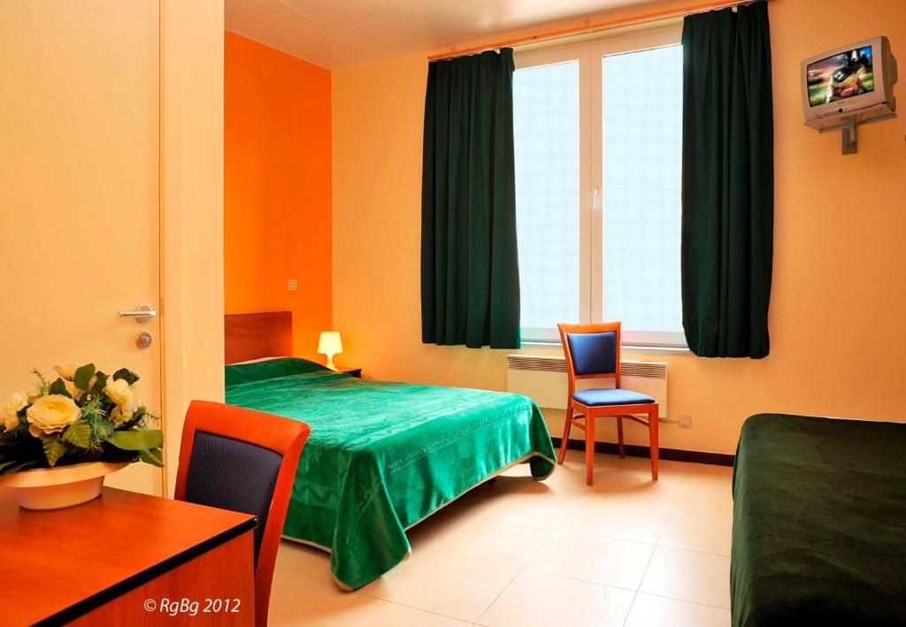 布鲁塞尔月亮酒店的酒店客房带一张床、一张桌子和椅子