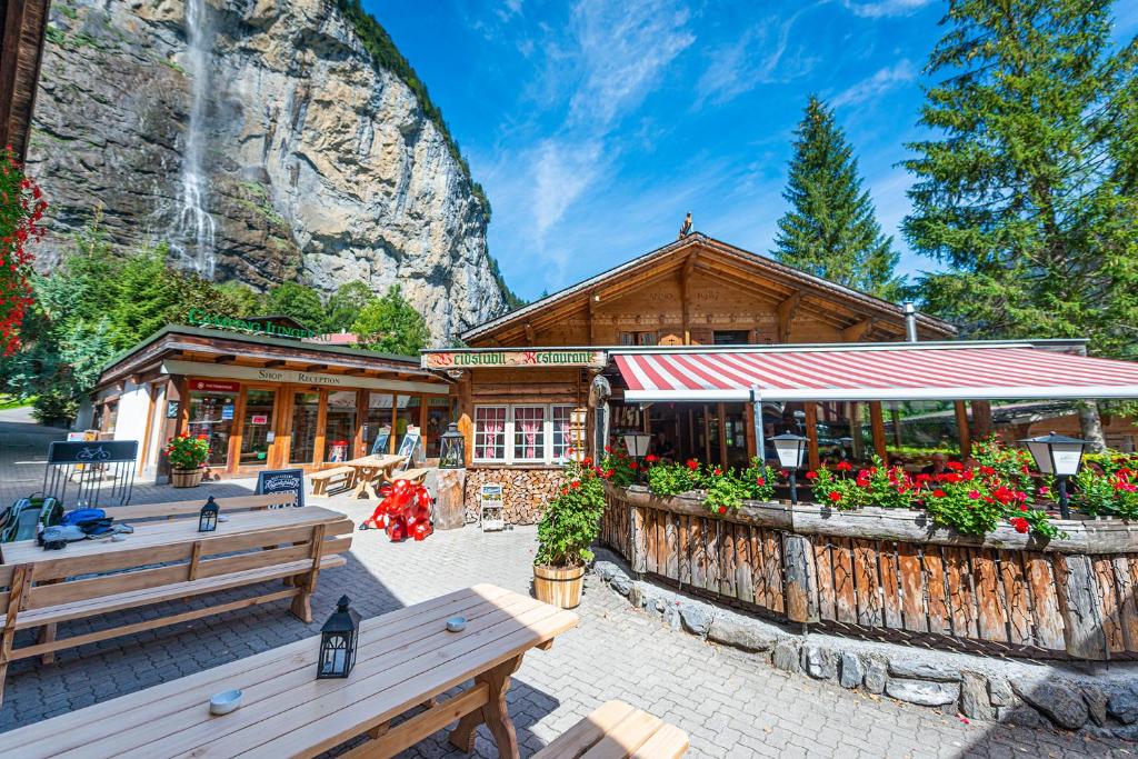 劳特布龙嫩Camping Jungfrau的前面有长椅和鲜花的建筑