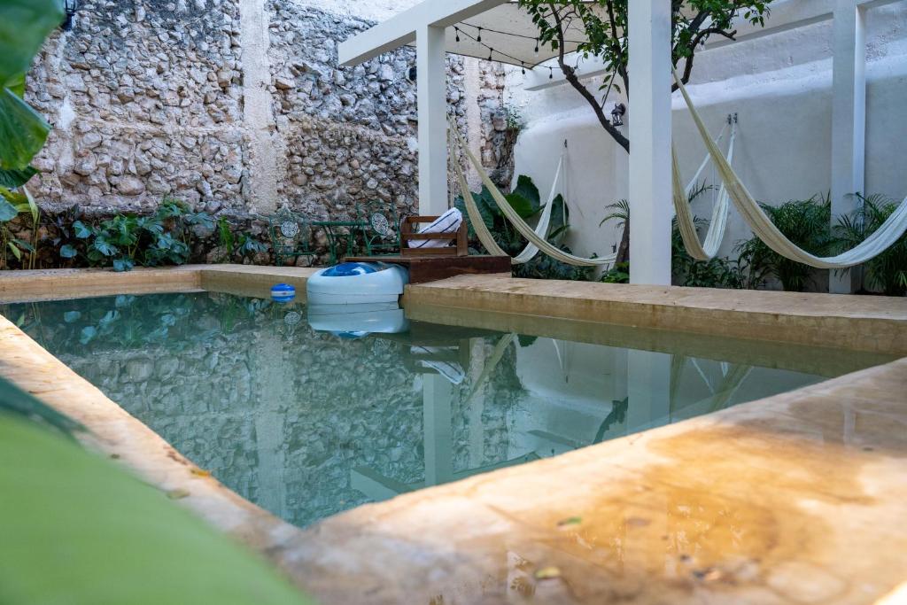 梅里达Hotel & Hostal Boutique Casa Garza的带淋浴和浴缸的游泳池