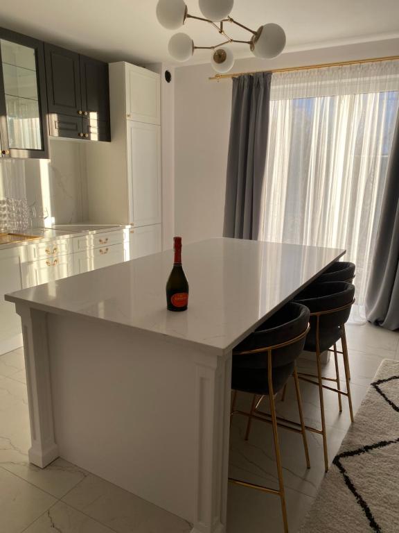 ZblewoApartament Złoty的白色的厨房,配有桌子和一瓶