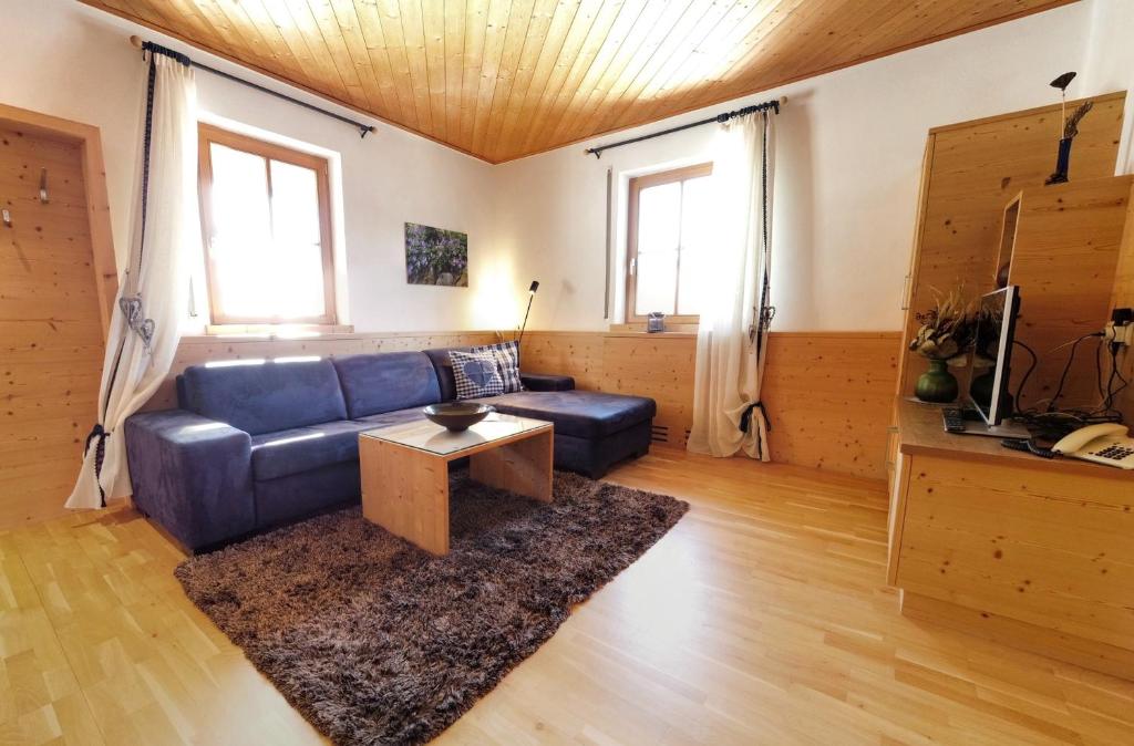 梅拉诺Appartements Grumserhof的客厅配有蓝色的沙发和桌子