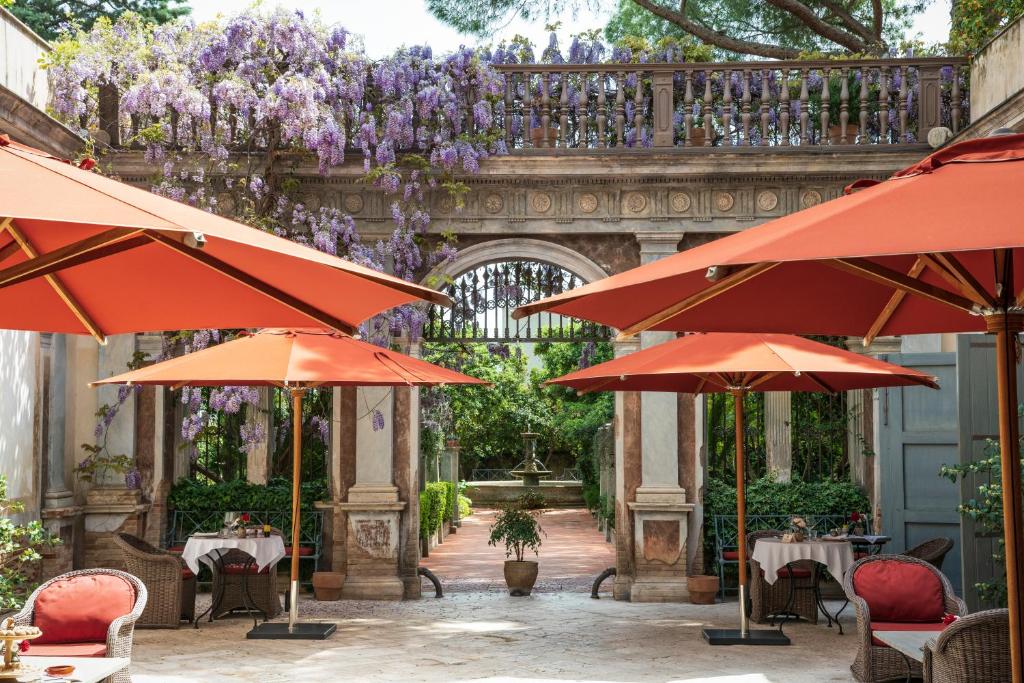 贝尔纳尔达玛格丽塔宫酒店的一个带桌子和遮阳伞的户外庭院