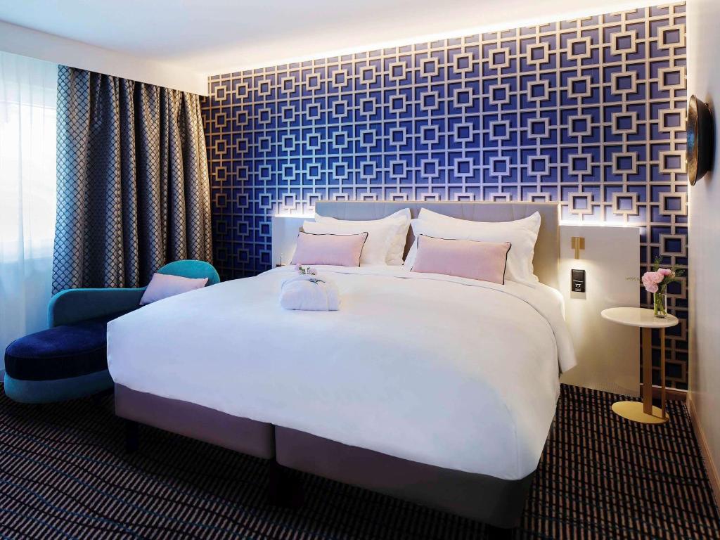 布雷根茨Grand Hotel Bregenz - MGallery Hotel Collection的一间卧室设有一张大床和蓝色的墙壁