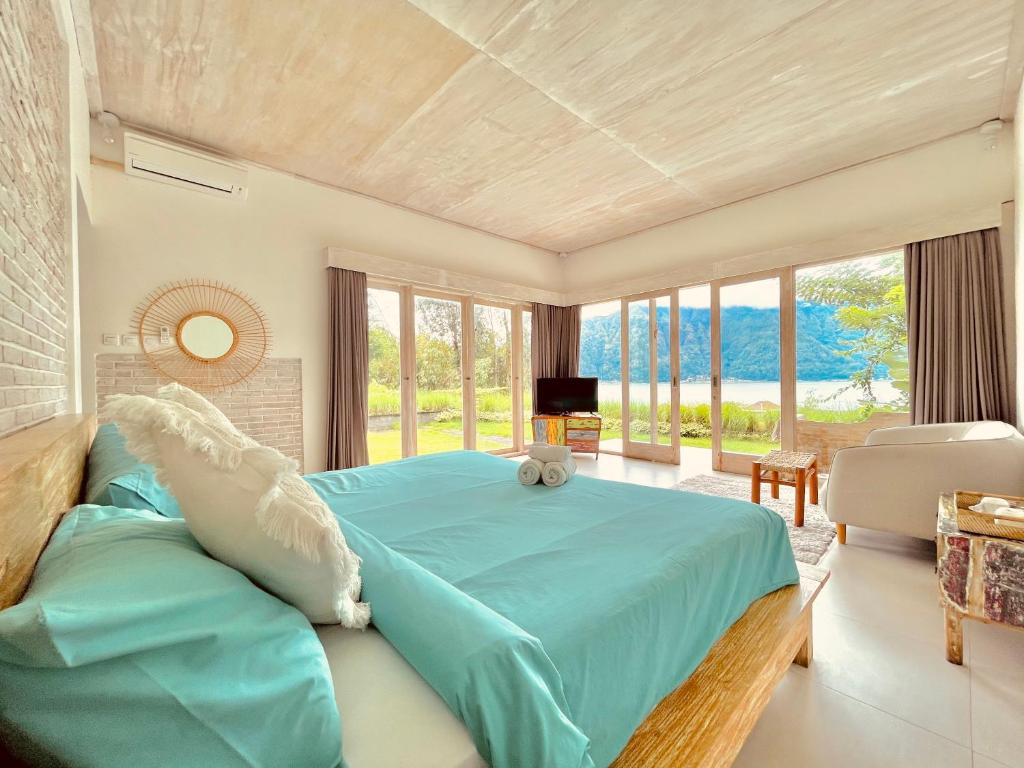 金塔马尼巴厘火山露台住宿加早餐旅馆的一间卧室设有蓝色的床和大窗户