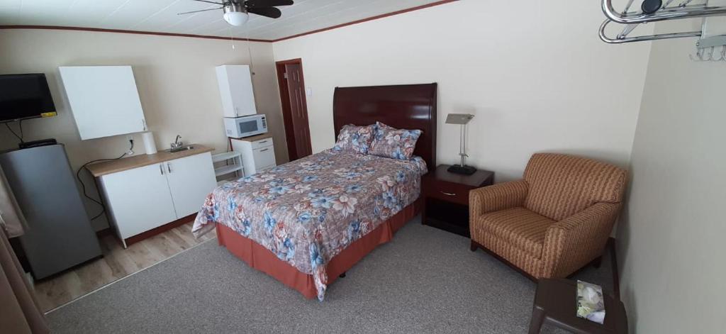 苏圣玛丽Super Nights Inn的一间卧室配有一张床和一把椅子