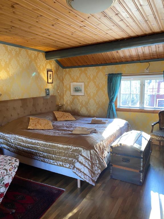 法伦Olsbacka cottage的一间卧室设有两张床和木制天花板