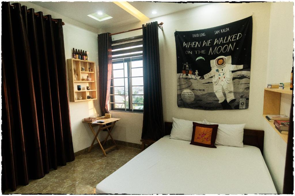 岘港Nhà của Elly的卧室配有一张床,墙上挂着一张海报