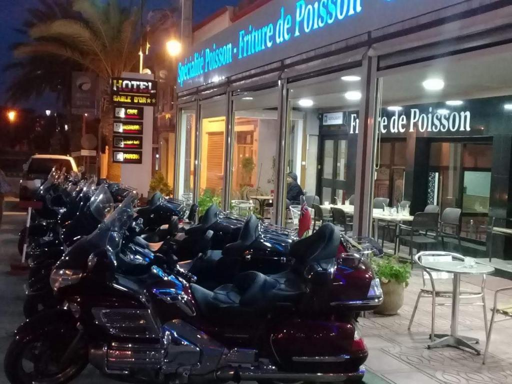 坦坦Hôtel Sable d'Or的一排停在餐厅前面的摩托车