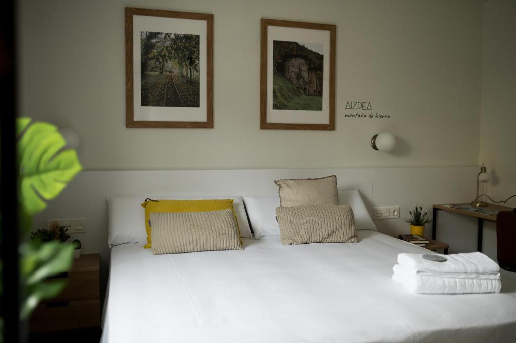 Villafranca de OrdiziaHOTEL ORDIZIA的卧室配有白色的床和2个枕头
