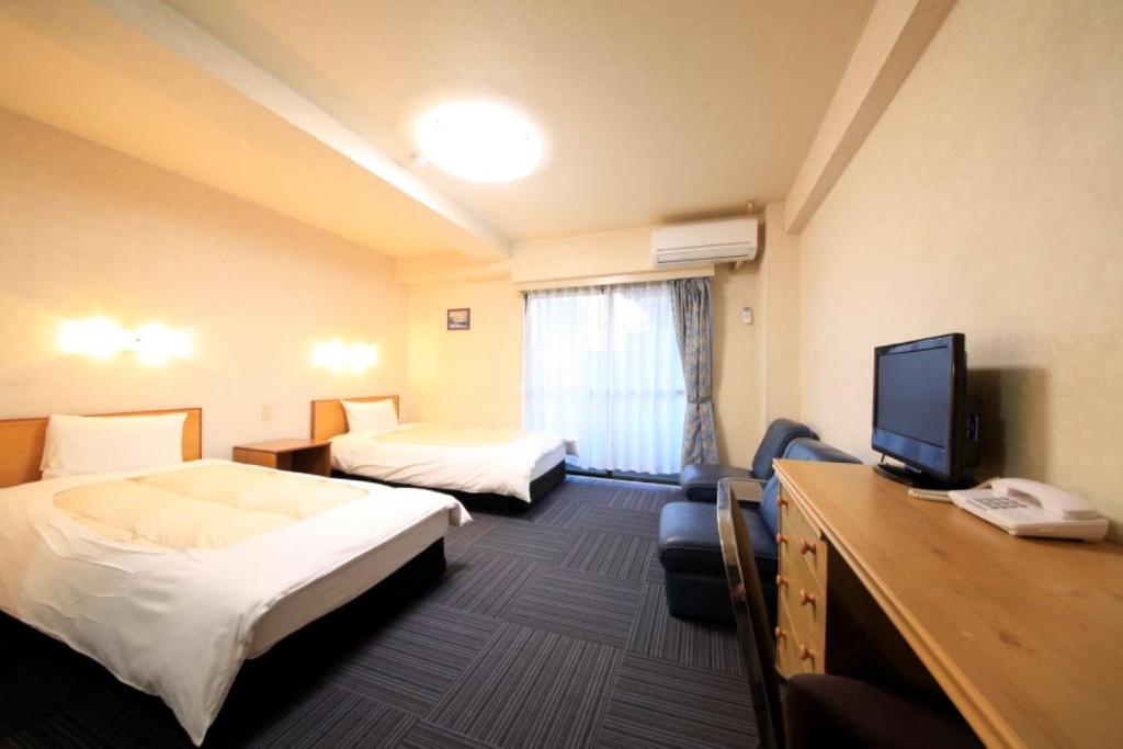 府中市Monthly Mansion Tokyo West 21 - Vacation STAY 10883的酒店客房设有两张床和一台平面电视。