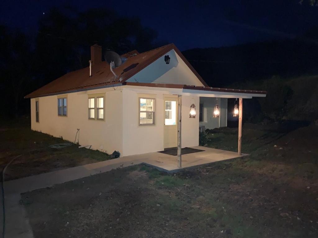 拉顿Valentine's Northern New Mexico Mountain Ranch on Colorado Border retreat的夜晚有灯的小白色房子