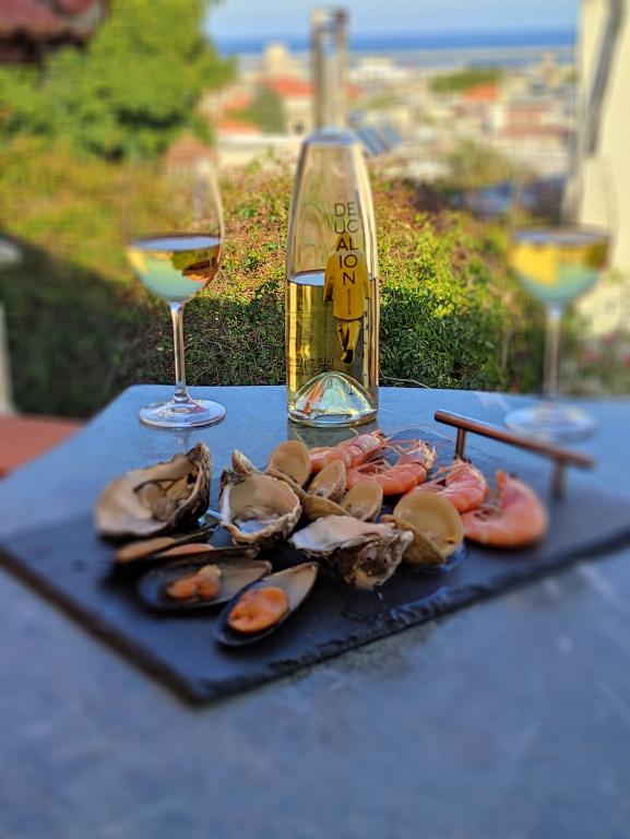 罗德镇Casa de Mikel的一张桌子,上面放着一盘牡 ⁇ 和一杯葡萄酒