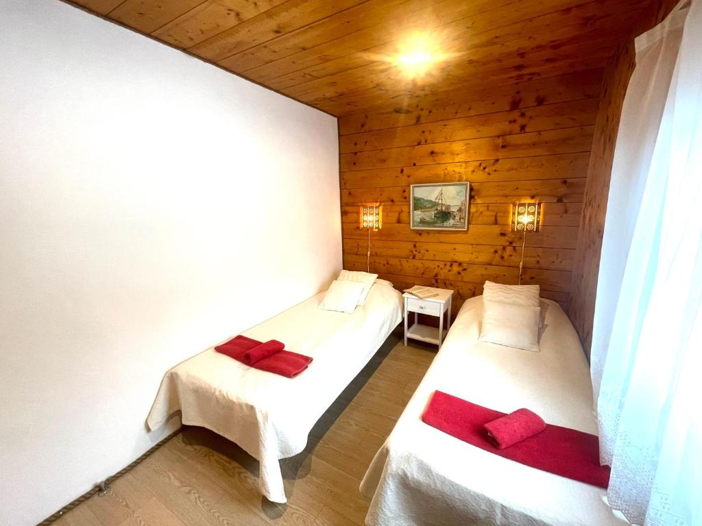 KäinaNurga Holiday Homes的木墙客房的两张床