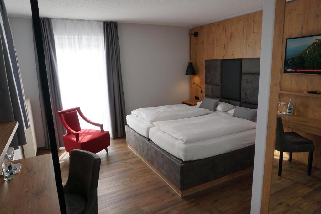 考夫博伊伦吉奥鲍姆酒店的酒店客房,配有一张床和一张红色椅子