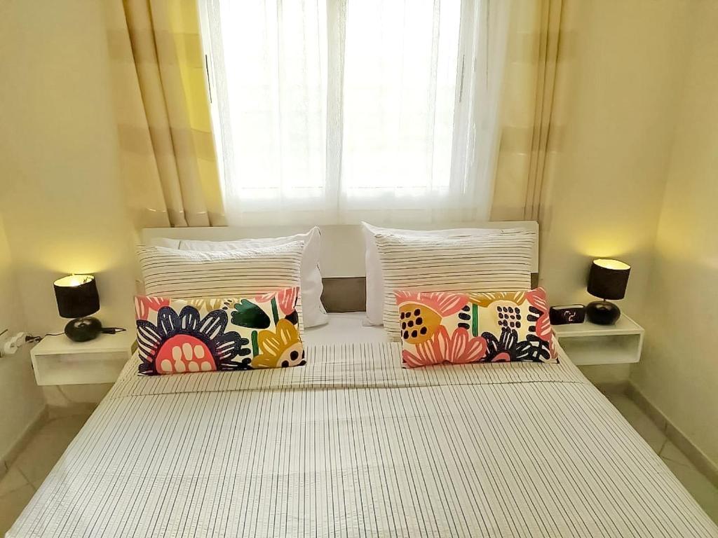 迈尔提勒Reta-Inn Martil Beach的一张带四个枕头的床和窗户