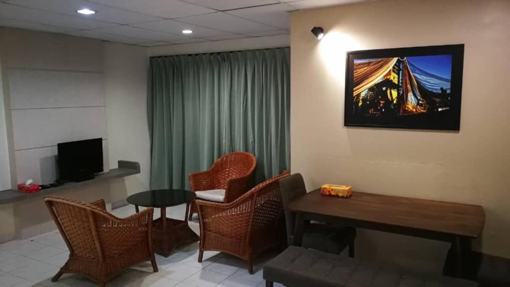 邦咯Pangkor staycation apartment的客厅配有桌椅和电视。