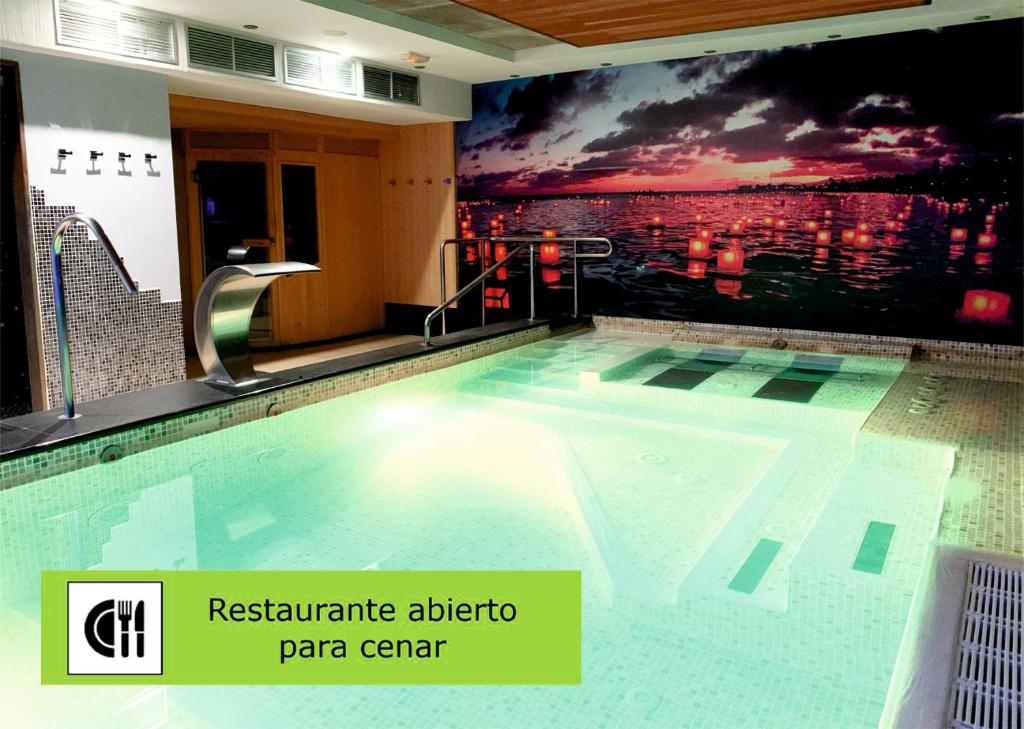莱昂莱昂中央SpaQH酒店的一座墙上画的建筑中的游泳池
