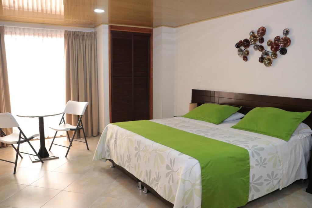 波哥大Hoteles Bogotá Inn Santa Bárbara Usaquén的一间卧室配有一张带绿色枕头的大床
