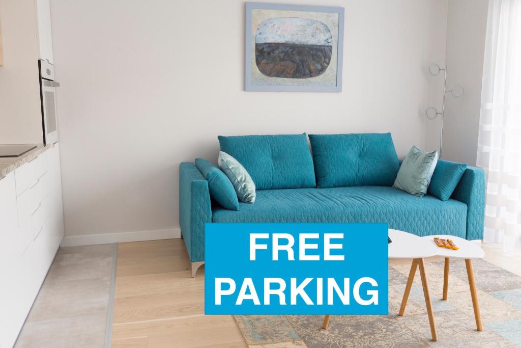 克拉科夫Chopin Apartments的客厅的蓝色沙发,带标志性的免费停车位