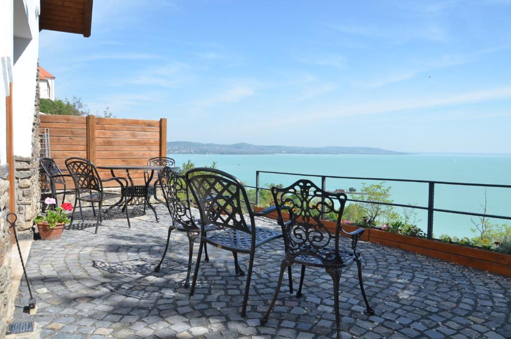 蒂豪尼萨托温的哈兹酒店的俯瞰水面的庭院里摆放着几把椅子和桌子