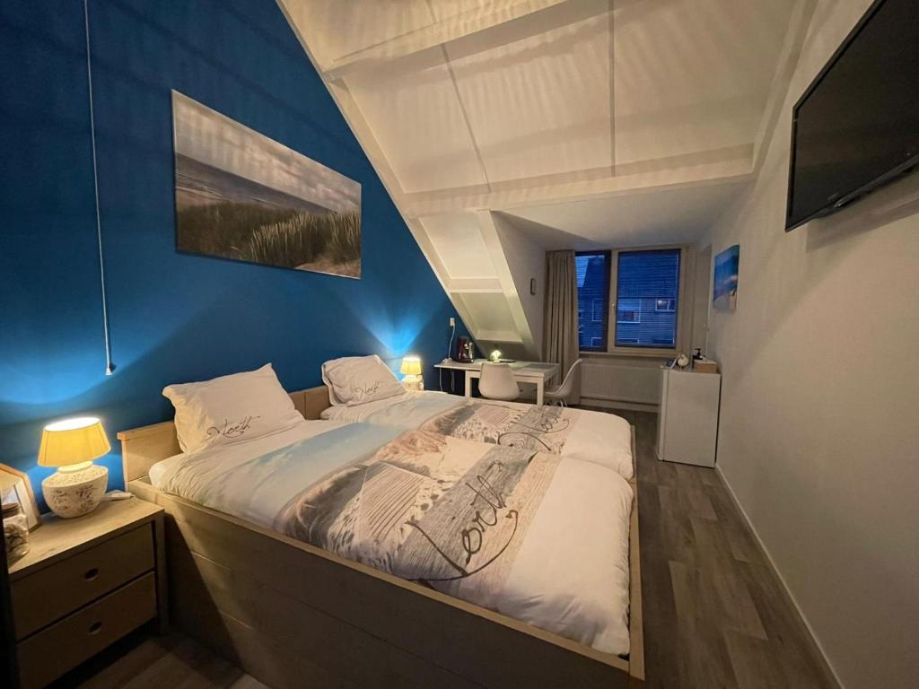 弗劳温普尔德Lise's Place的一间卧室设有一张蓝色墙壁的大床