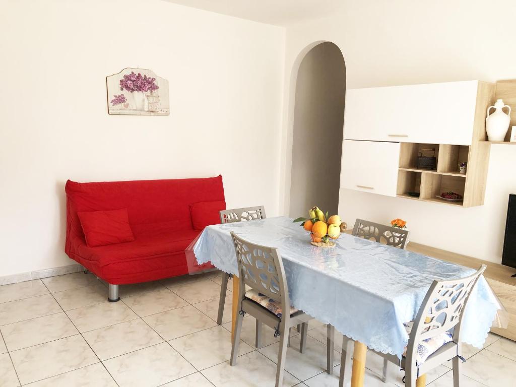 孔韦尔萨诺Cupersanum B&B的客厅配有桌子和红色沙发